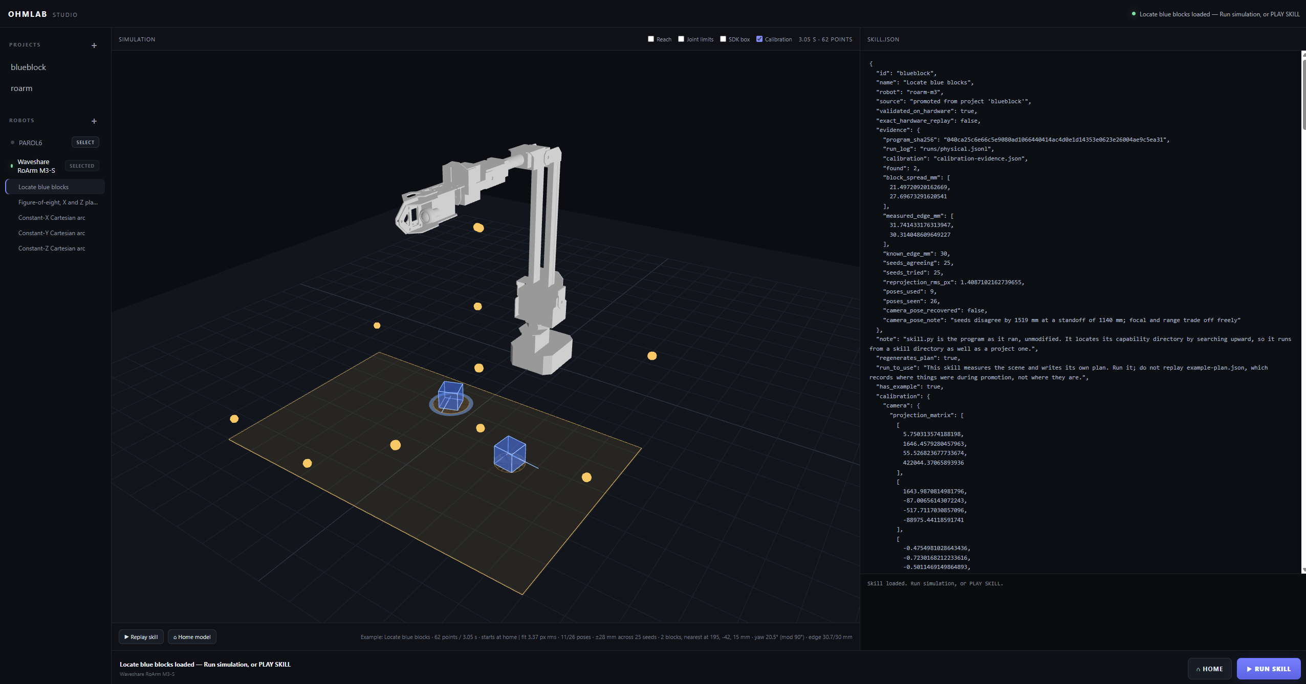 Ohm Lab Studio: a RoArm M3-S simulated above a work surface with detected blocks and calibration points, next to the loaded skill definition